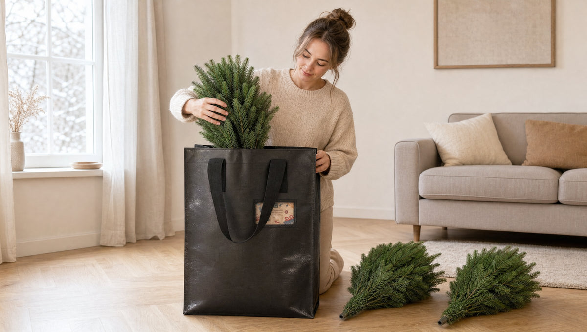 Zusammengeklappte Teile eines künstlichen Weihnachtsbaums werden nach dem Fest in die schwarze Aufbewahrungstasche gepackt